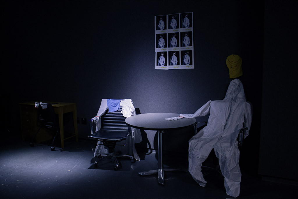 Two lab coats on chairs by a dimly-lit table