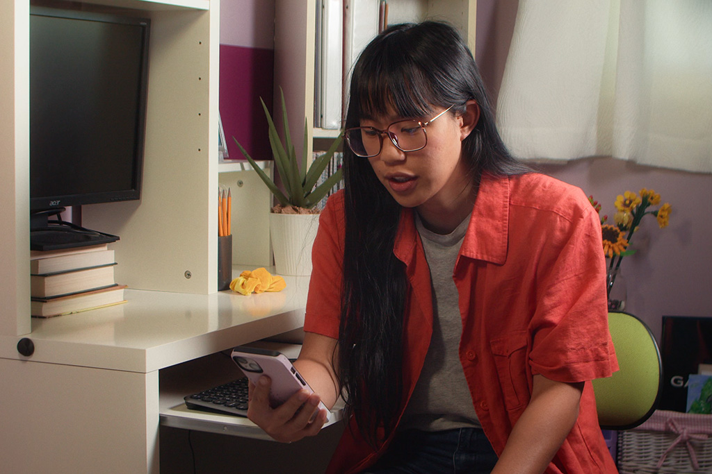 Woman in colorful room, looking at phone